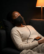 Ansiktsmask – värme eller massage – kvinna med mask i fåtöljen